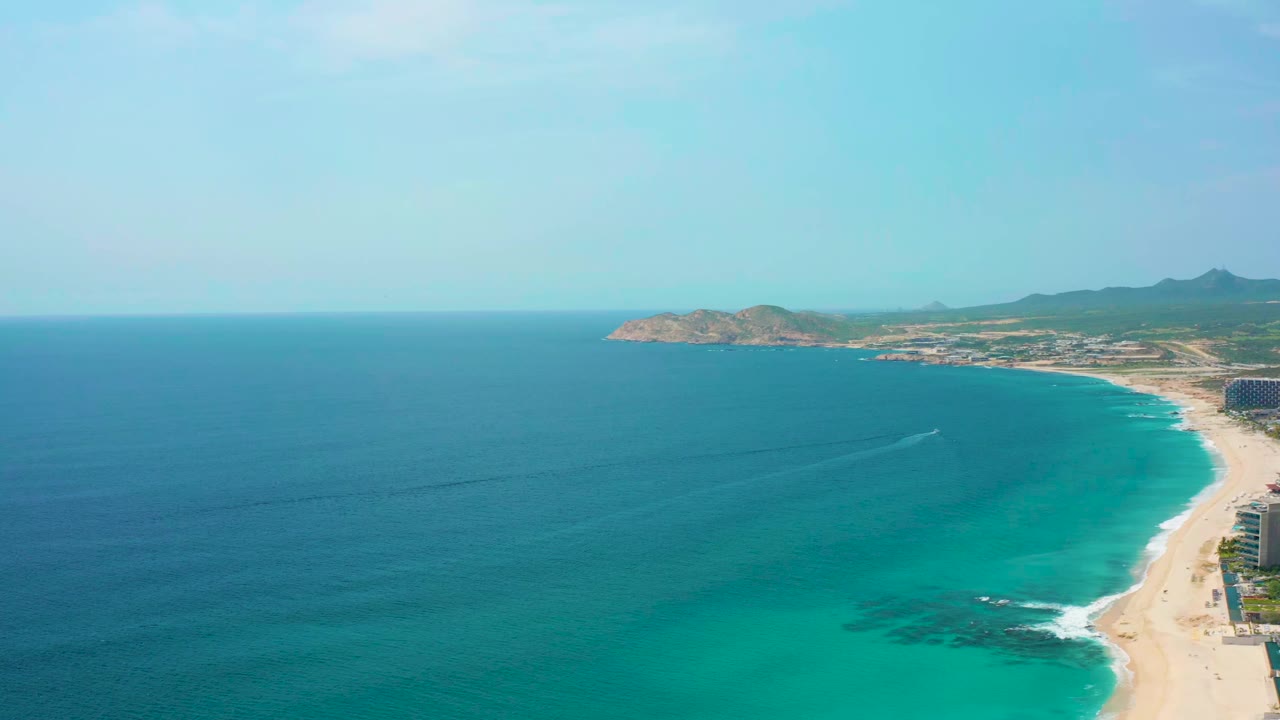 Aerial view at Desert Park Natural Reserve showing a small white wake cutting across blue sea toward the sandy shoreline, with no visible people.