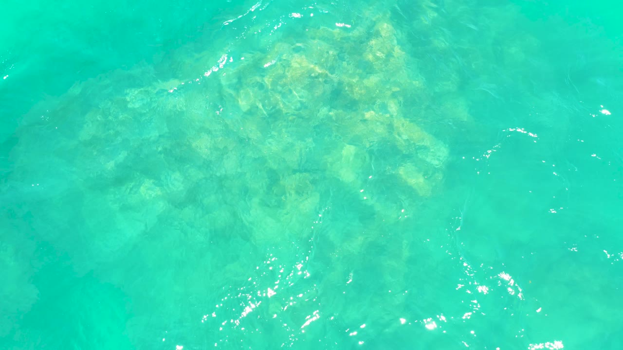 Submerged rocks under rippled turquoise water