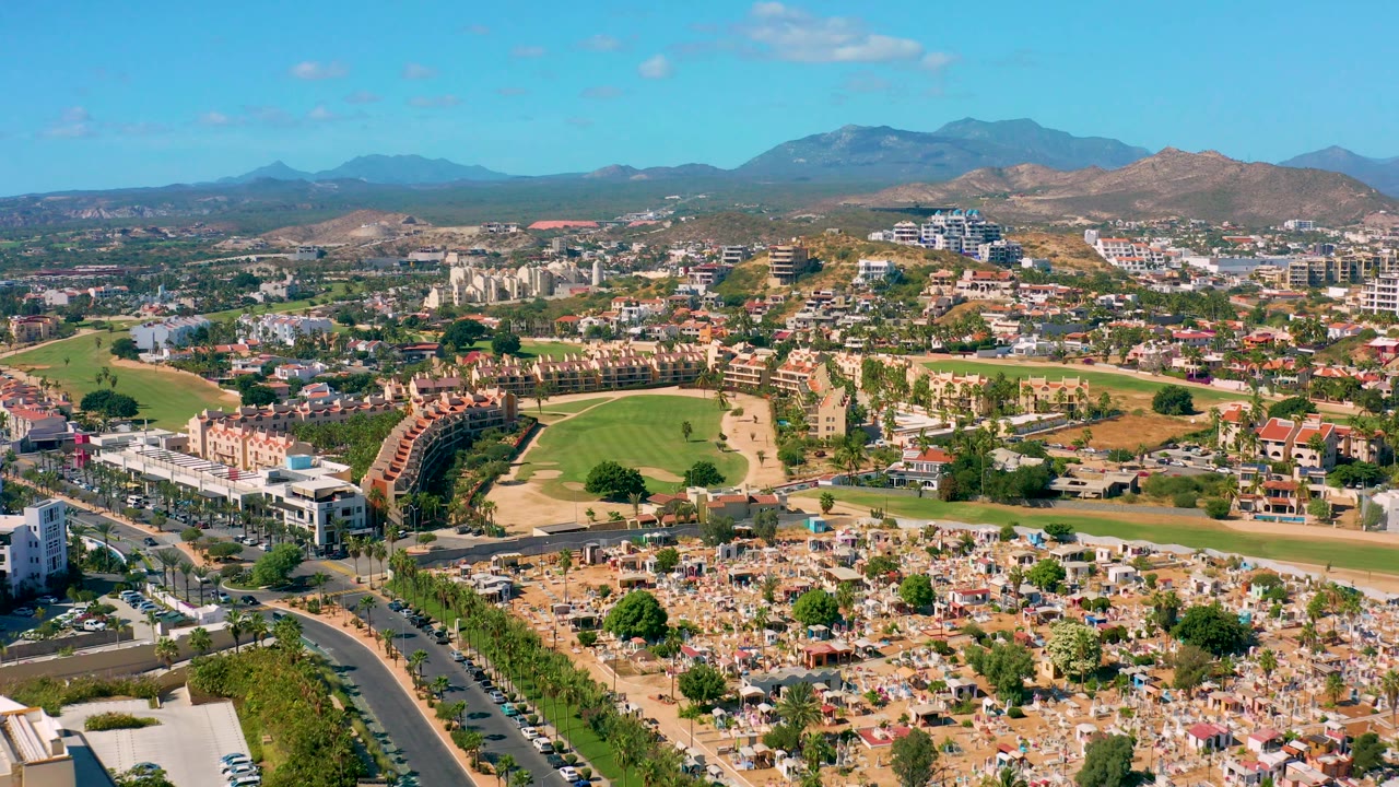 Aerial neighborhood view with green golf fairways and distant mountains