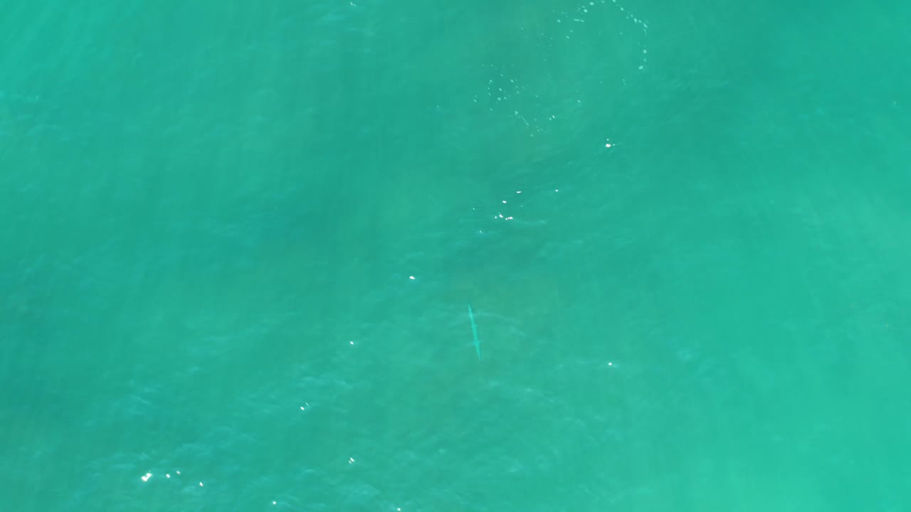Turquoise ocean water with faint underwater patches and small ripples.