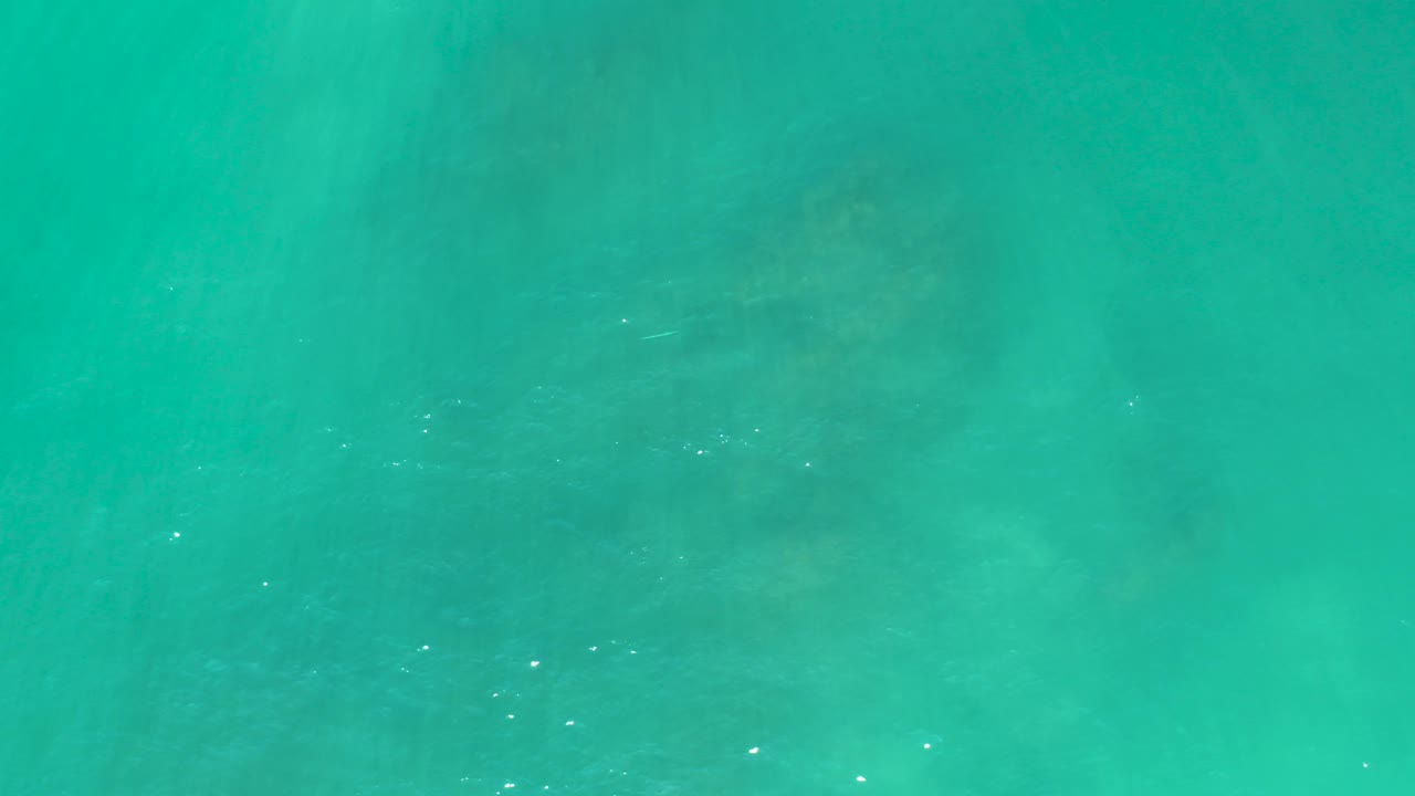 Turquoise ocean water with faint submerged seabed patches.