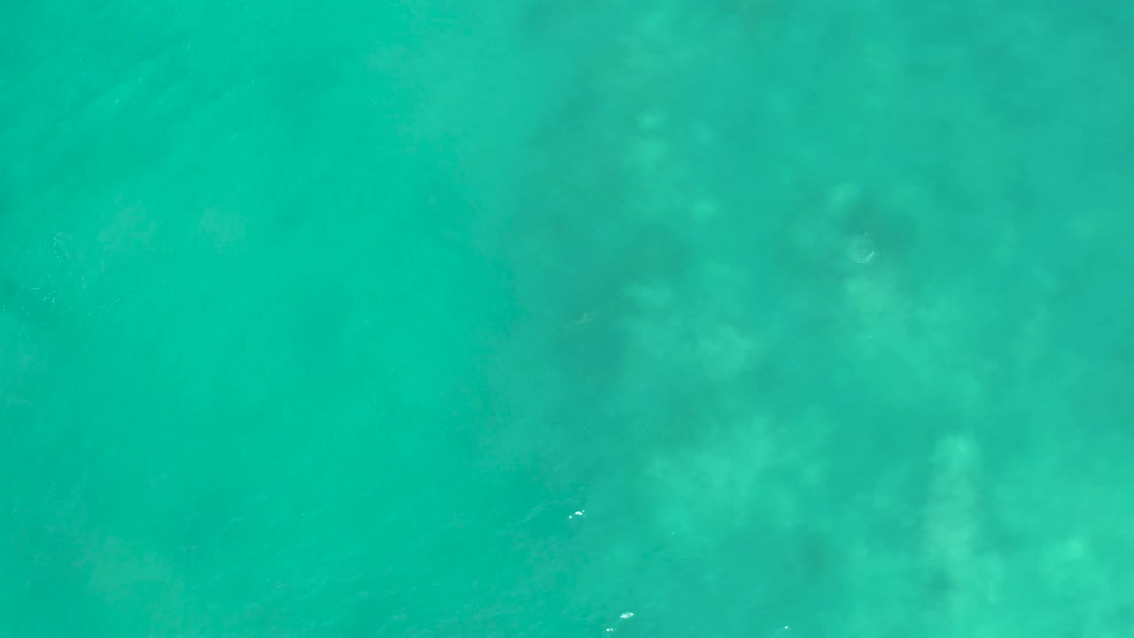 Shallow ocean water at San Luis Beach East Cape Los Cabos, Mexico, reveals pale underwater formations through a green-turquoise surface and no visible people.