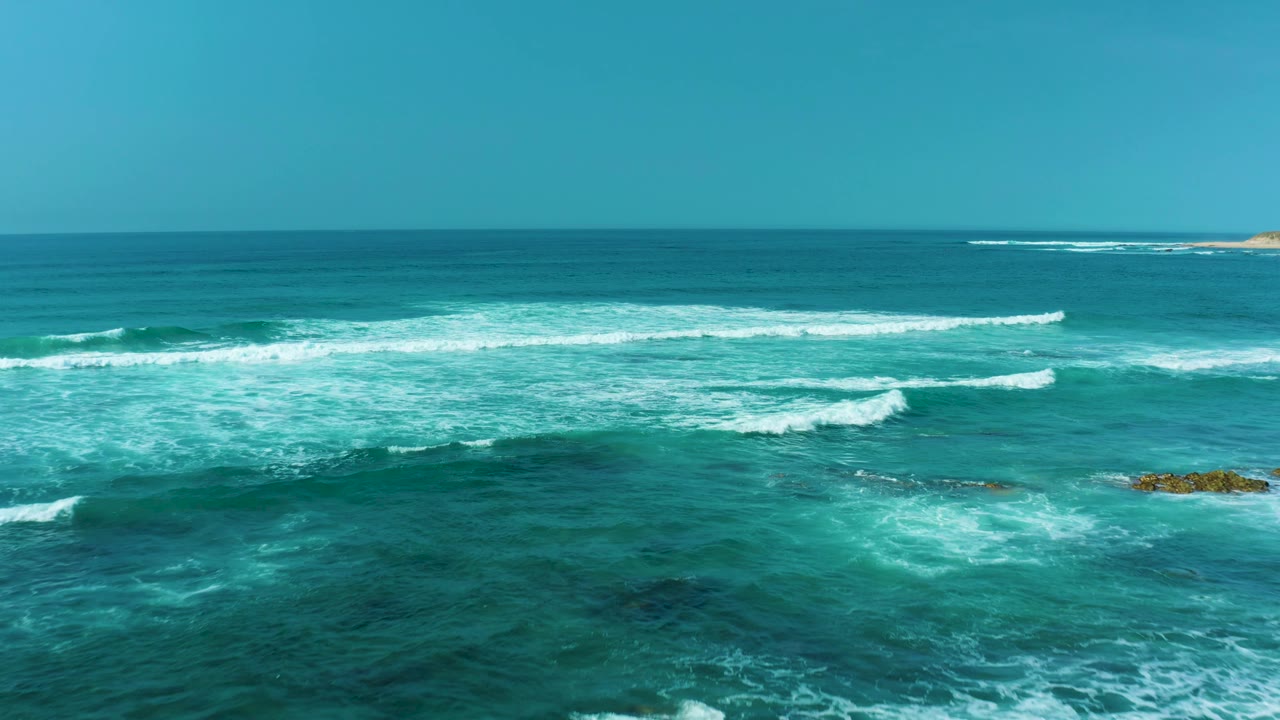 Turquoise ocean waves breaking over shallow water