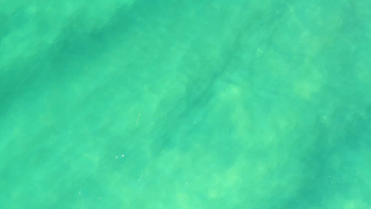 Bright turquoise shallow water in Campestre San Jose del Cabo BCS Mexico, with soft sunlit refraction marks over the sand and no visible people.