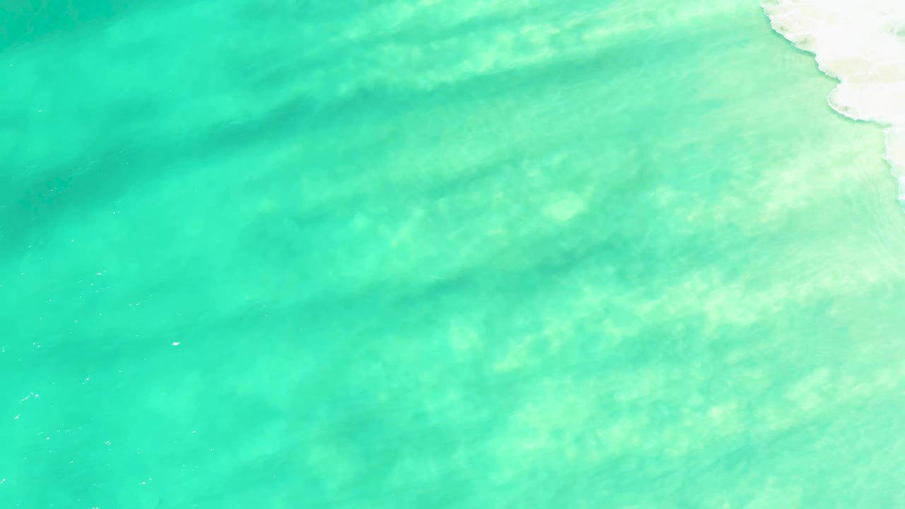 Opening frame of shallow turquoise coastal water at Campestre San Jose Del Cabo BCS Mexico, with pale sand visible below soft ripples and no visible people.