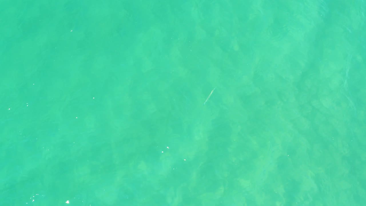 At 0:03, shallow aqua water fills the frame with diagonal ripple streaks, visible bottom texture, and no visible people.