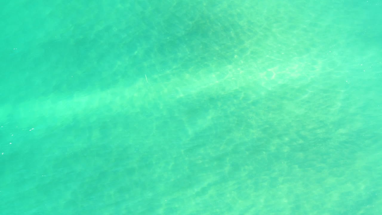Shallow blue green water with rippled light patterns