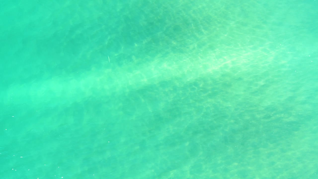 Transparent turquoise ocean surface in Campestre San Jose Del Cabo BCS Mexico with a pale seabed visible through the water and no visible people.