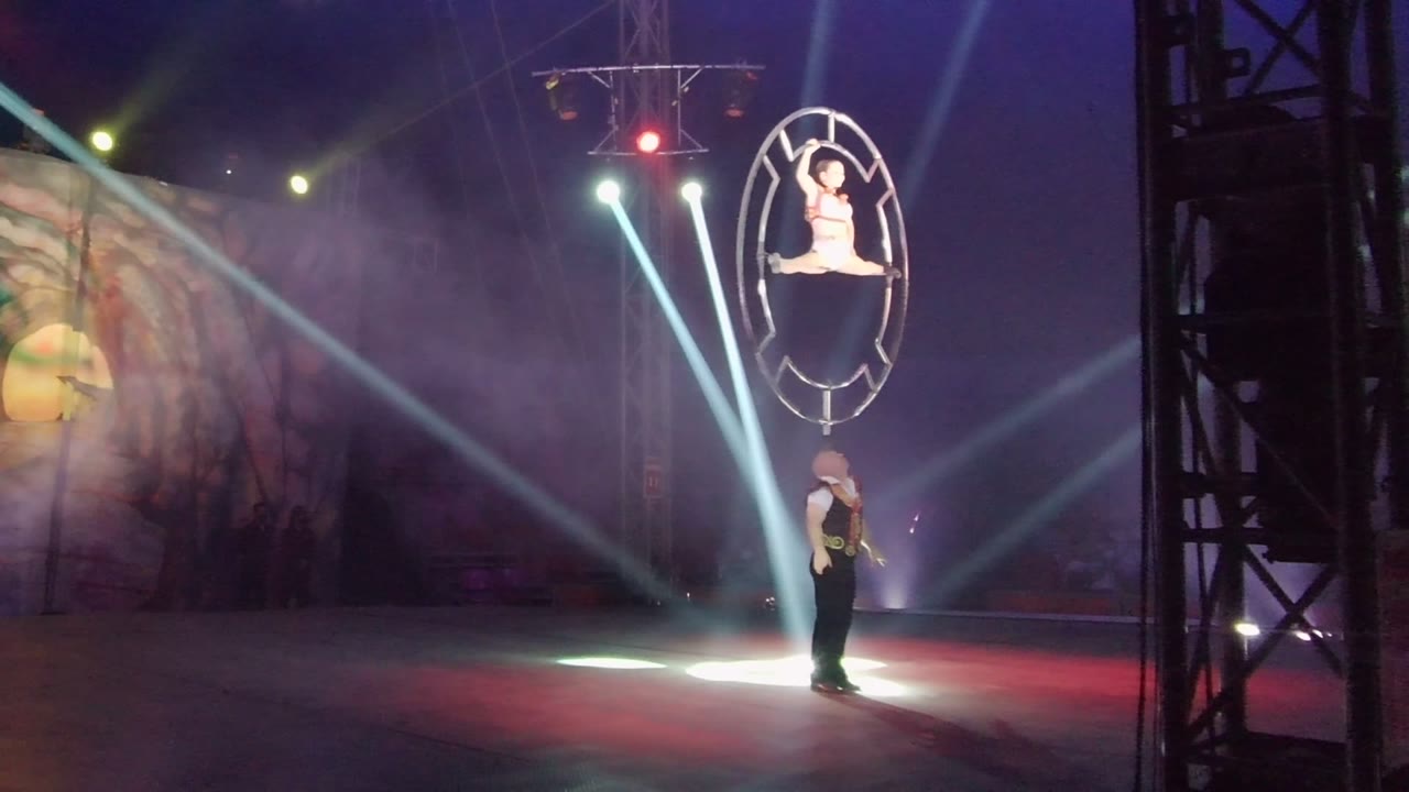 In San Jose del Cabo BCS Mexico, the circular aerial hoop hangs high as the performer remains posed and the dancer below stands in a pool of bright stage light.