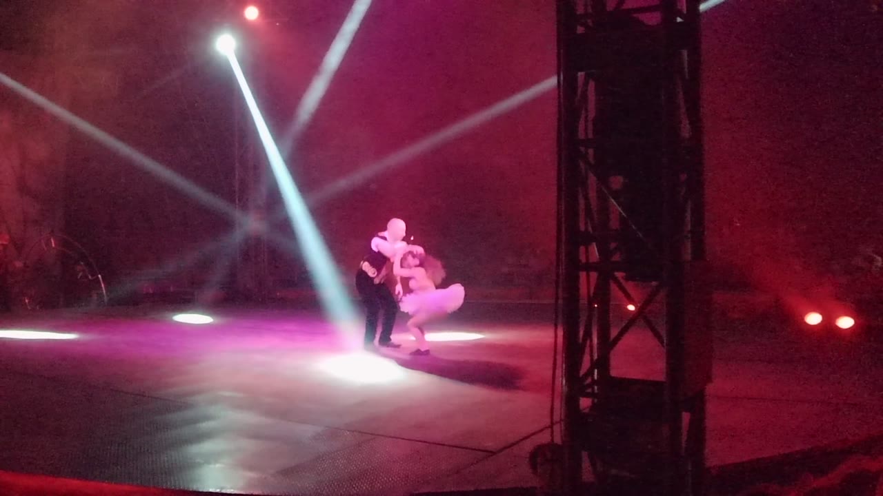 Male dancer begins lifting female dancer on stage.