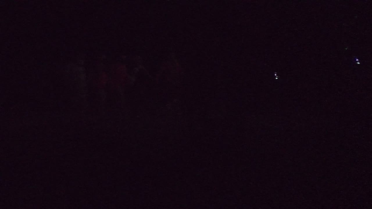 Dark side-stage frame in San Jose Del Cabo BCS Mexico with several people walking onto a stage while the audience is barely visible in the background.