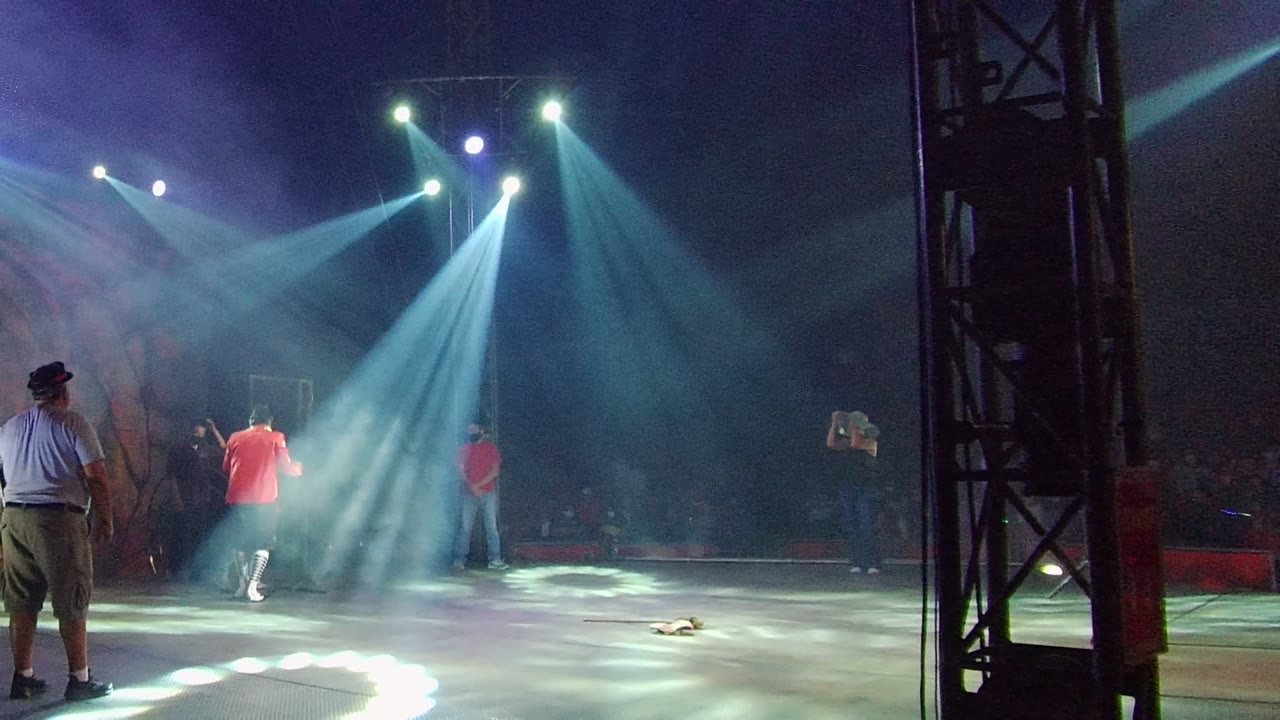 In San Jose del Cabo BCS Mexico, the two central performers appear to embrace beneath blue-white spotlights while a person in a light blue shirt stands in the foreground.