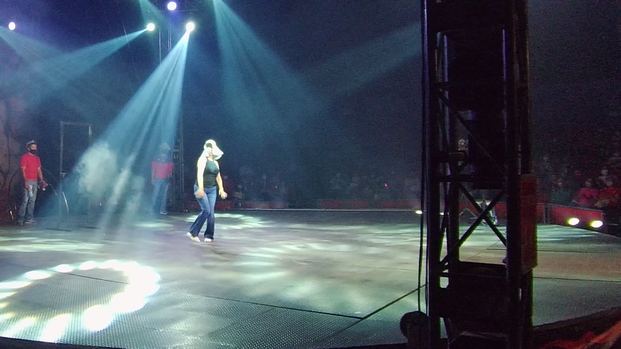 In San Jose Del Cabo BCS Mexico, the performer moves farther across the lit stage as angled beams and haze brighten the floor pattern.