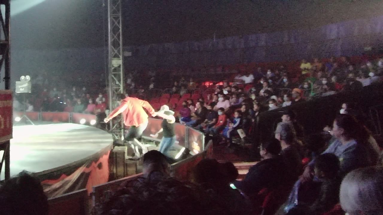 Two people begin moving across the stage in front of the crowd.
