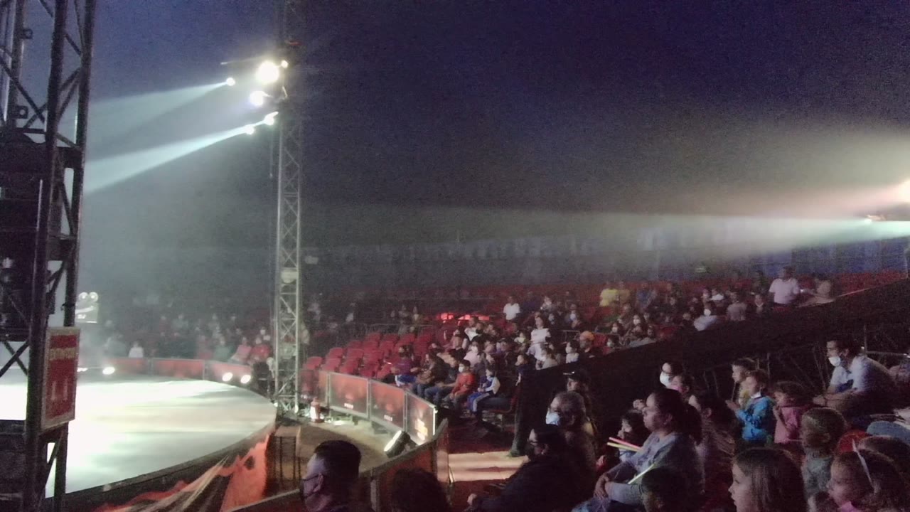 Audience members in San Jose Del Cabo BCS Mexico sit beside a curved stage edge as white spotlights shine across a dark theater at the start of the clip.
