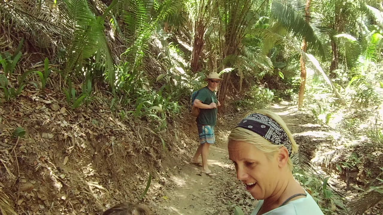 Man in hat on dirt path with woman in foreground