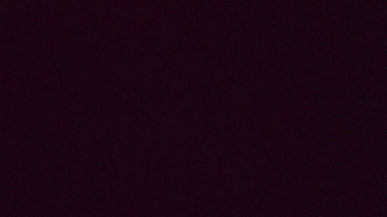 Mostly dark, blurred interior frame from the Guadalajara, Mexico clip, with only faint warm color and no visible people.