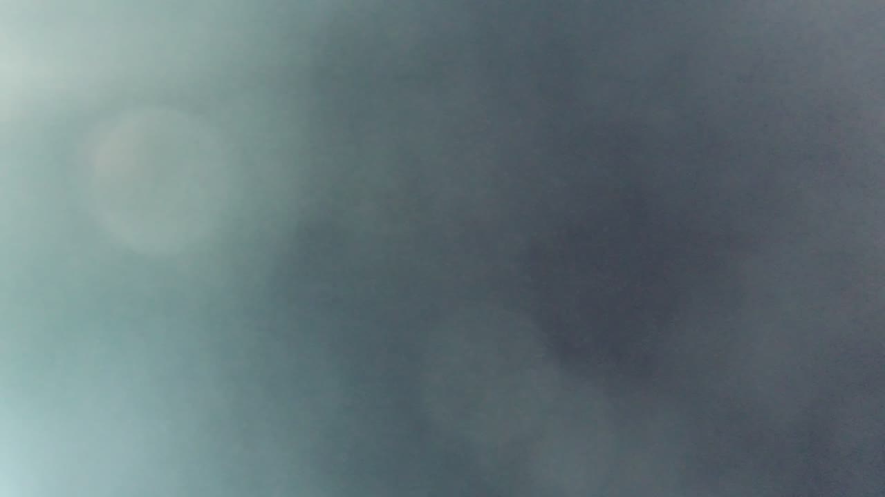 A Cabo Pulmo, Mexico frame showing indistinct blue-green blur and dark soft patches behind a fogged window, with no visible people.