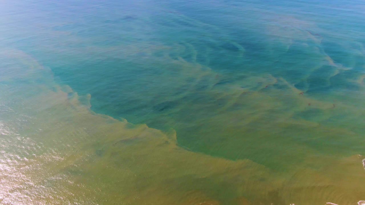 Aerial-looking view of Buzzards Beach East Cape BCS Mexico water with darker blue patches above green shallower-looking currents and no visible people.