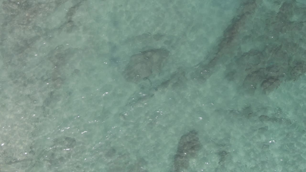Clear shallow water with ripples and underwater rock shadows