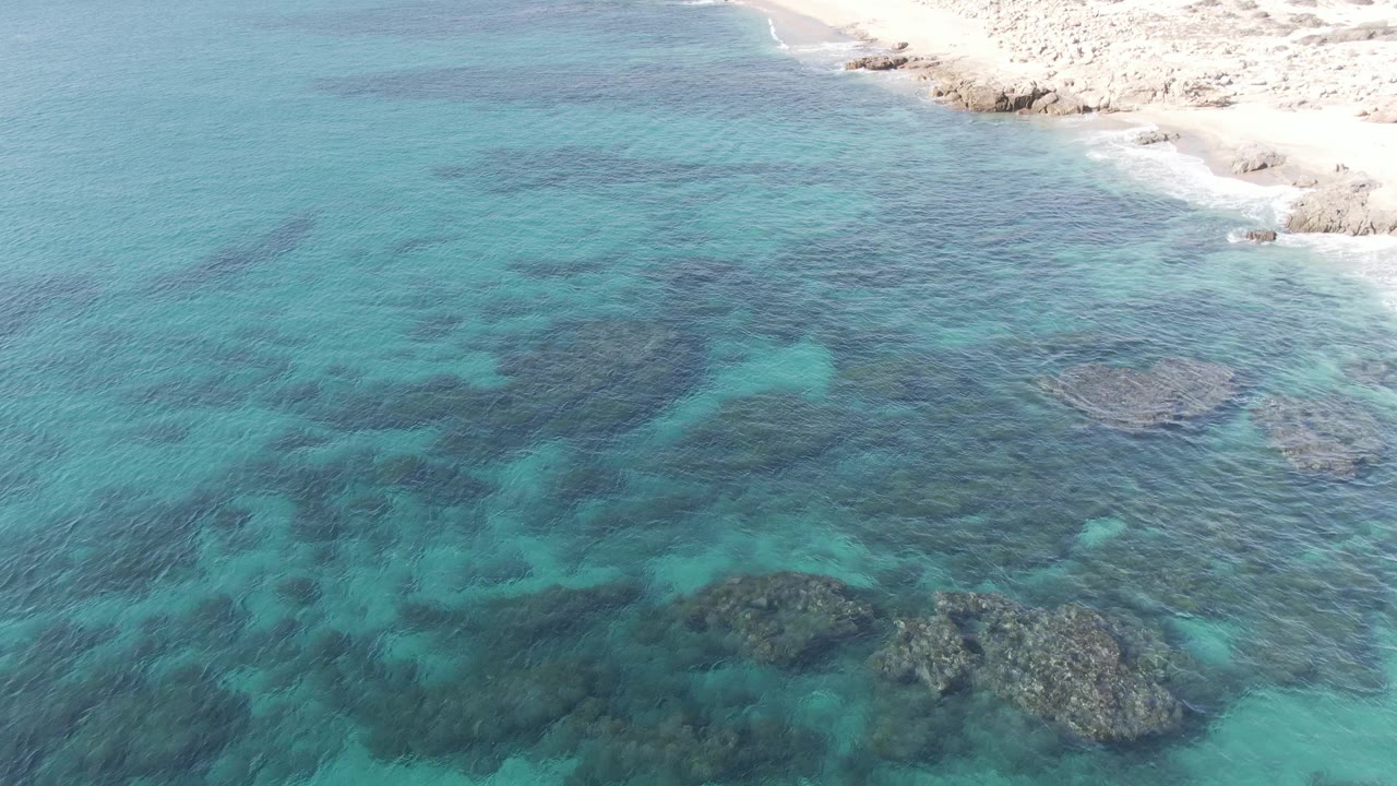 Aerial view of shallow turquoise water and beach edge