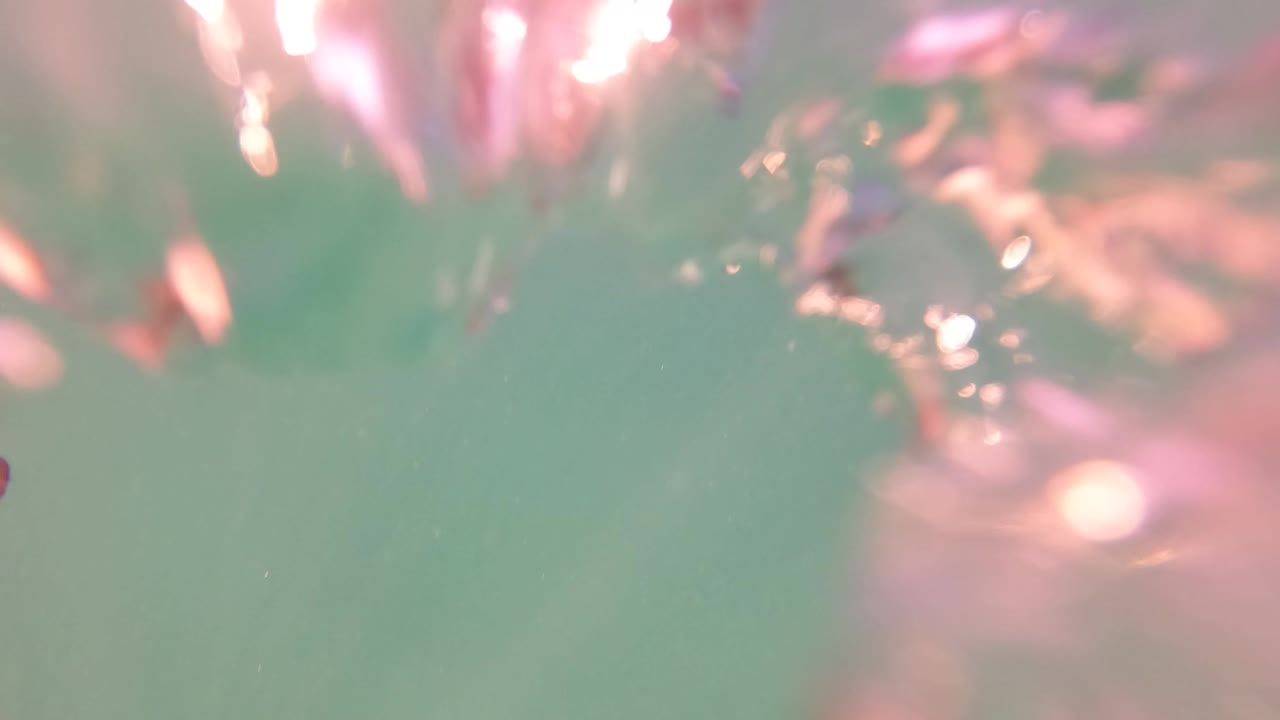 Blurred underwater surface with pink reflections