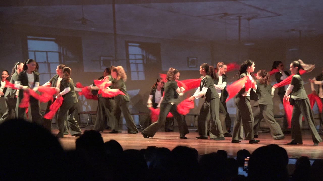 At 0:00 in San Jose Del Cabo BCS Mexico, a large dance group in green and white costumes spreads across the stage while red scarves move in front of audience silhouettes.