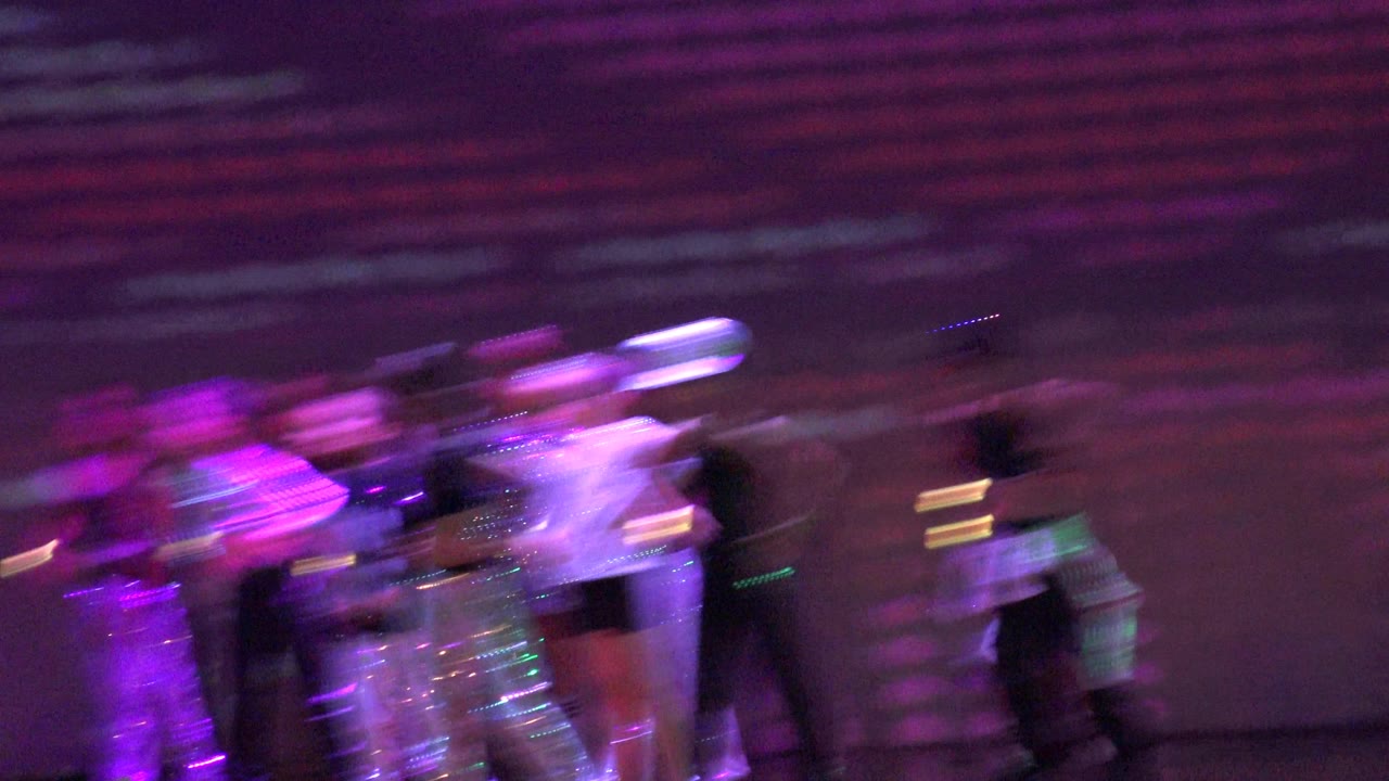 Motion-blurred performers move across the stage in San Jose Del Cabo BCS Mexico, with purple light and a dark stage floor dominating the frame.