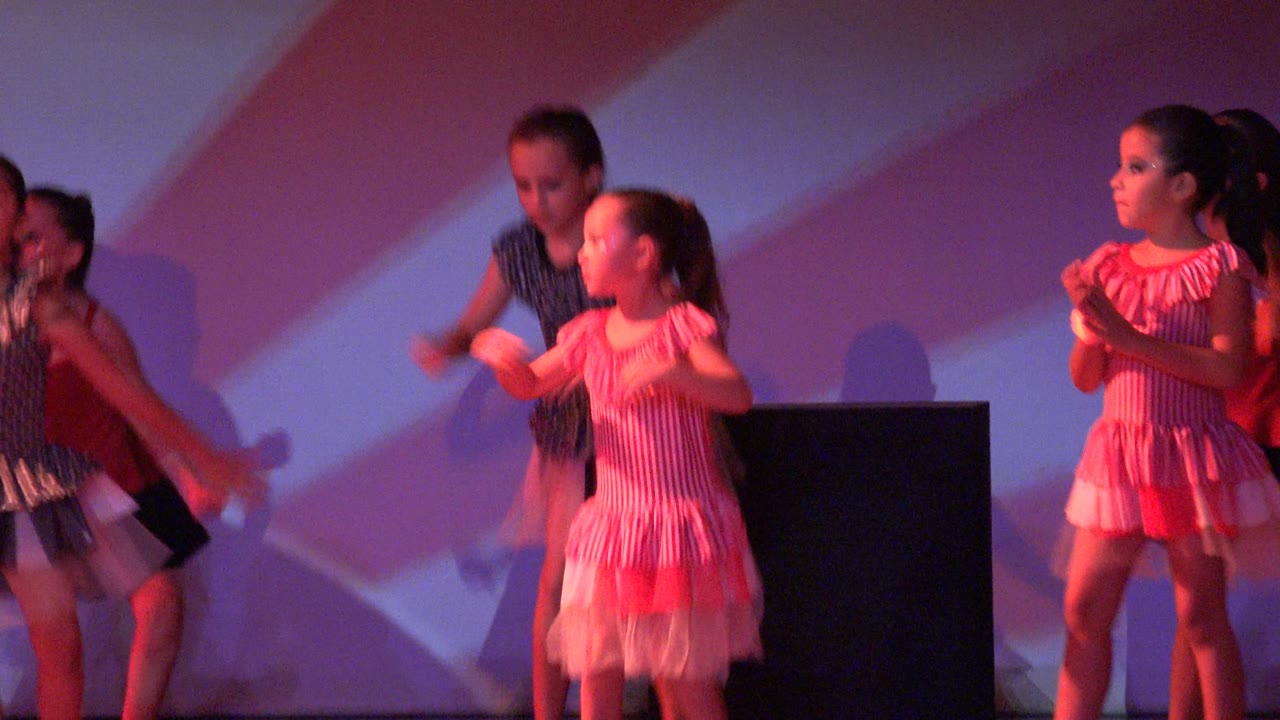 Child dancers continue arm choreography on stage.