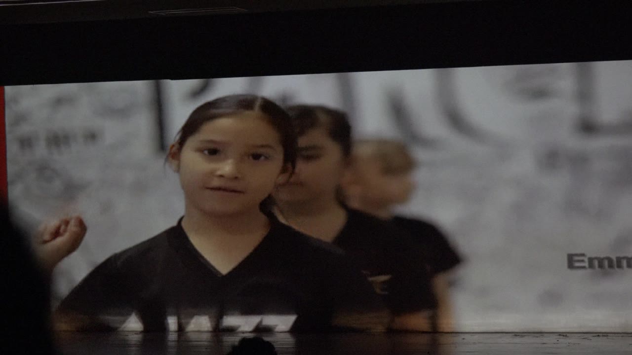 Child facing camera with other children behind her