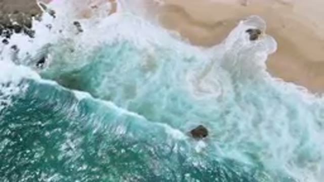 LAGUNA BEACH EAST CAPE BCS MEXICO-2023: Aerial Beach With A Wave Crashing On The Shore