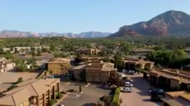 SEDONA ARIZONA USA-2023: Mountains In The Background Of A Town With A Parking Lot