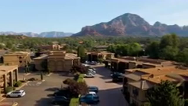 SEDONA ARIZONA USA-2023: Mountains In The Distance Behind A Town With A Parking Lot