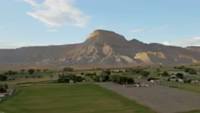 PALISADES COLORADO USA-2023: Mountains In The Distance With A Green Field And A Road