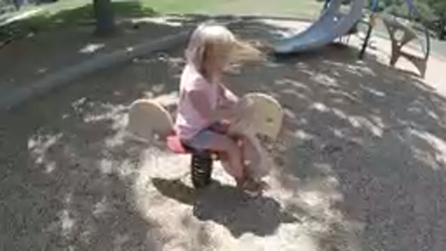 Little Girl Riding A Skateboard On A Playground