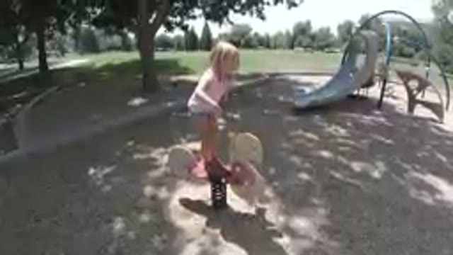 Little Girl That Is Standing On A Skateboard