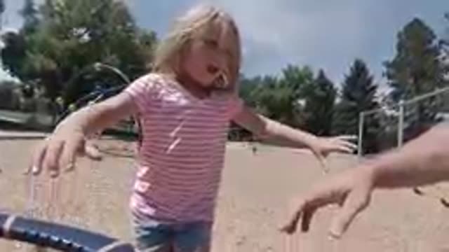 Little Girl Standing On A Playground Slide