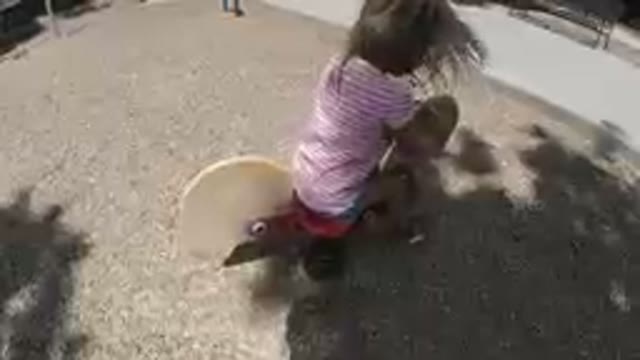 Sitting On A Wooden Toy On A Playground