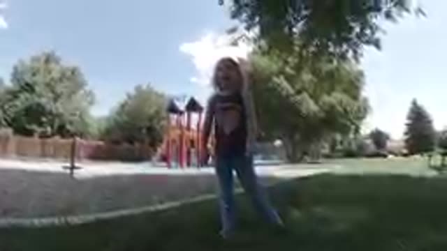 COLORADO, UNITED STATES-2019: Curious Little Girl Kneeling on Grass