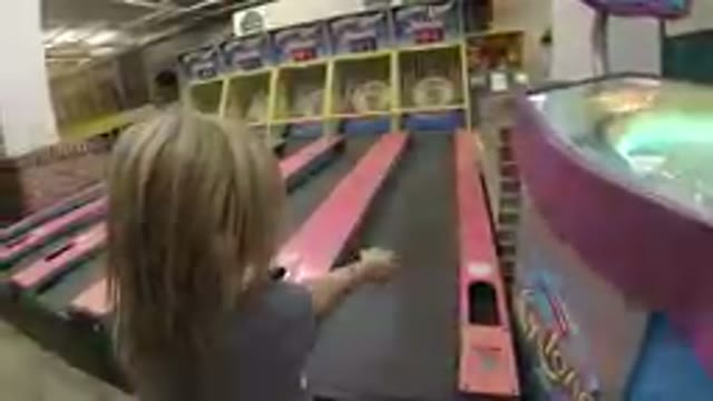 Little Cute Girl Playing Skee-Ball