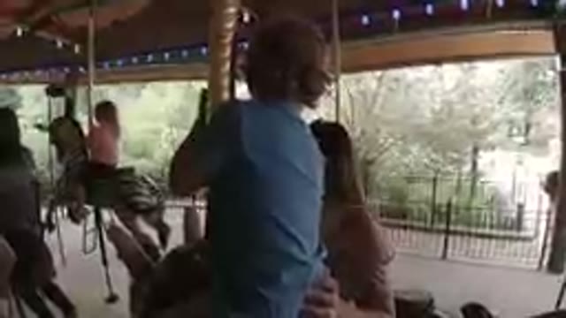 Amusement Park - Little Boy Riding a Carousel