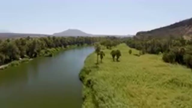 SAN IGNACIO BCS MEXICO-2023: River Running Through A Lush Green Field Next To A