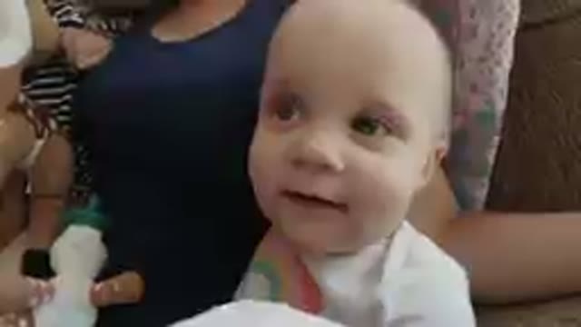 Baby Sitting On A Couch With A Stuffed Animal