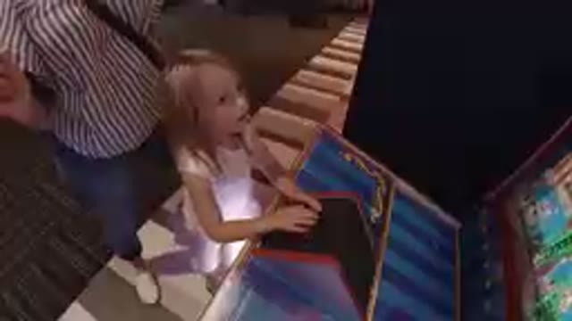 Denver, United States-2019: Little Girl Plays Arcade Game As Mom Watches