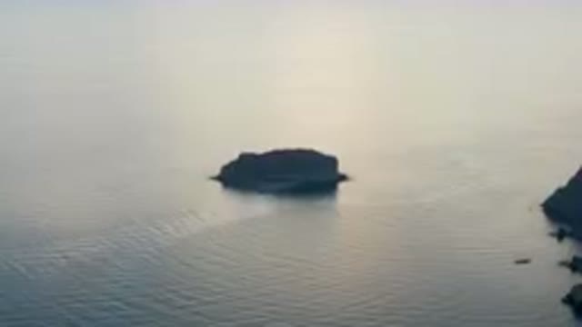 DANZANTE BAY LORETO BCS MEXICO-2023: Small Boat Floating Near a Rock in Calm Waters