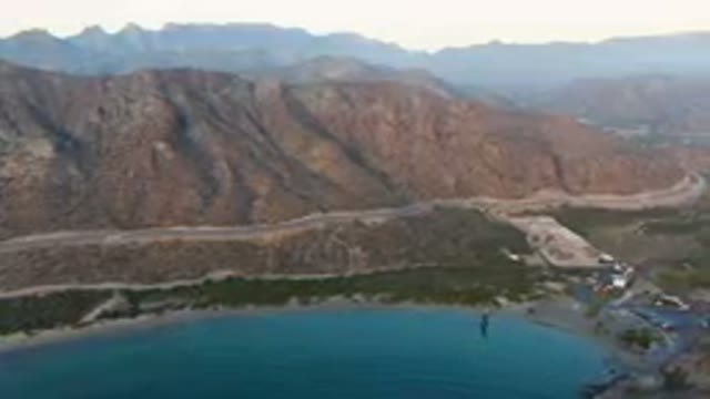 DANZANTE BAY LORETO BCS MEXICO-2023: Mountains And A Body Of Water With A Road