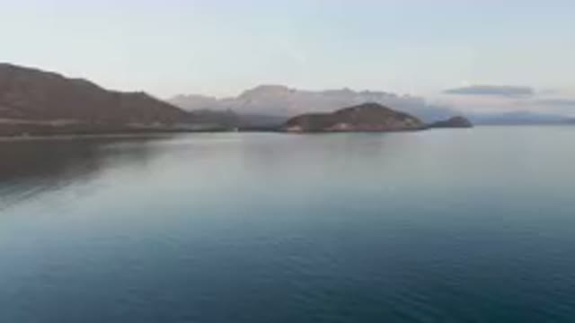 DANZANTE BAY LORETO BCS MEXICO-2023: Boat Floating On Calm Waters Near Mountains