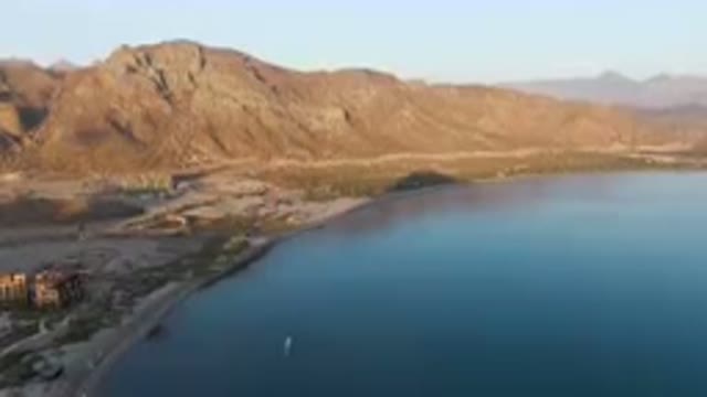 DANZANTE BAY LORETO BCS MEXICO-2023: Beach With A Boat In The Water And Mountains