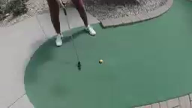COLORADO, UNITED STATES-2019: Woman Playing Golf On A Green Putting Hole With A Yellow Ball