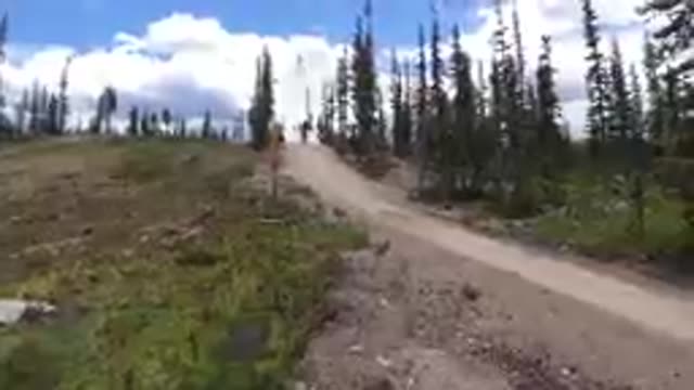 Dirt Road Going Up A Hill With A Sign On It